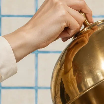 Hand lifting a gold cloche, an explored direction for Bono